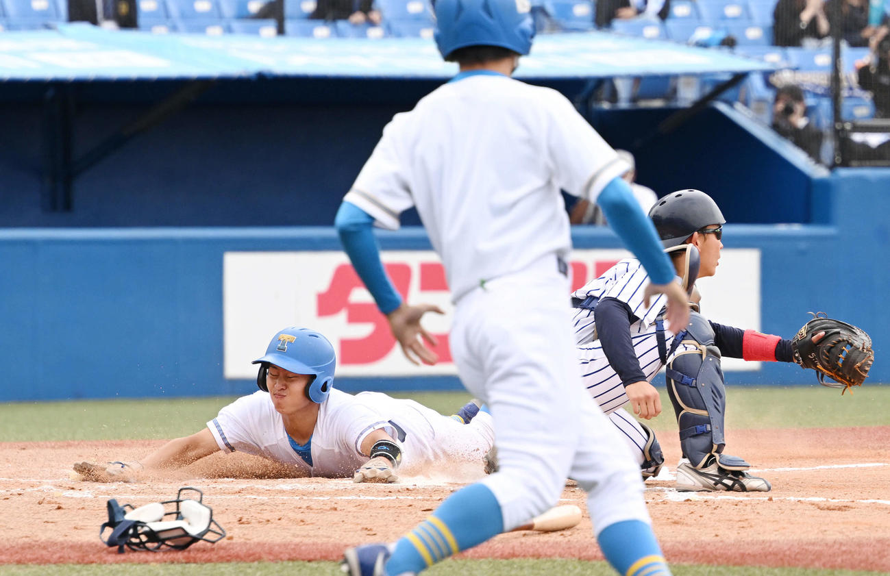 東大対立大　7回表東大1死三塁、代打赤井の犠飛から生還する別府。捕手戸丸（撮影・滝沢徹郎）