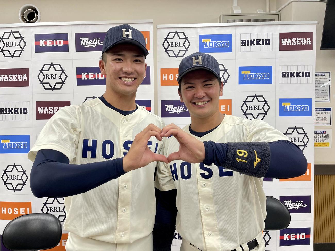 笑顔でハートをつくる法大の篠木健太郎（左）と村上喬一朗のバッテリー（撮影・保坂恭子）