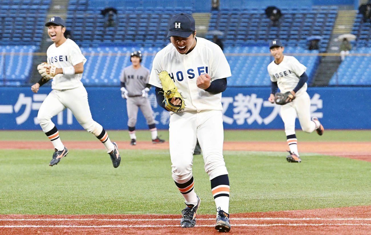 9回表慶大2死満塁、朝日を投ゴロに仕留めた吉鶴（手前）はガッツポーズする（撮影・滝沢徹郎）