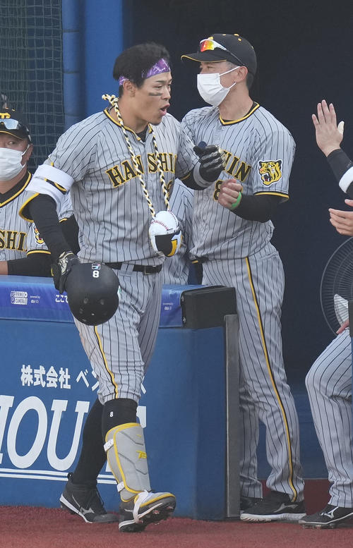 DeNA対阪神　4回表阪神2死、中越えソロ本塁打を放った佐藤輝（左手前）にメダルをかける矢野監督（撮影・鈴木みどり）