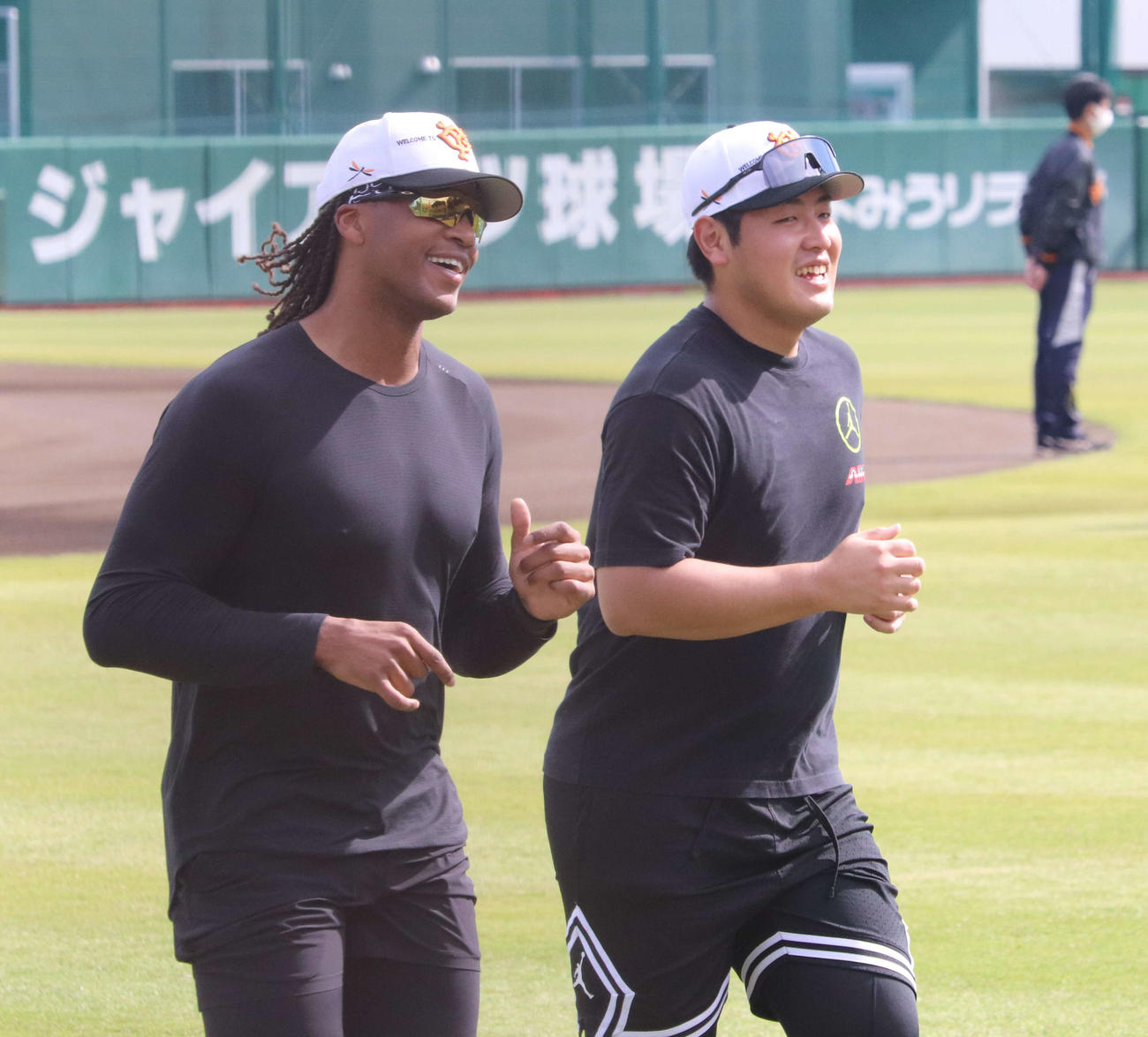 ジャイアンツ球場での秋季練習、笑顔でランニングする巨人ウォーカー（左）と岡本和（撮影・小早川宗一郎）