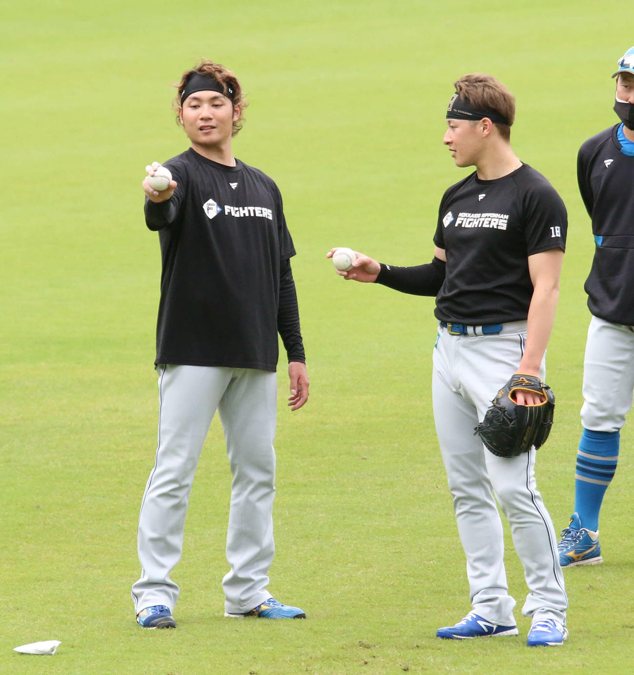 鎌ケ谷で日本ハム伊藤（左）からスライダーを教わる吉田（撮影・木下大輔）