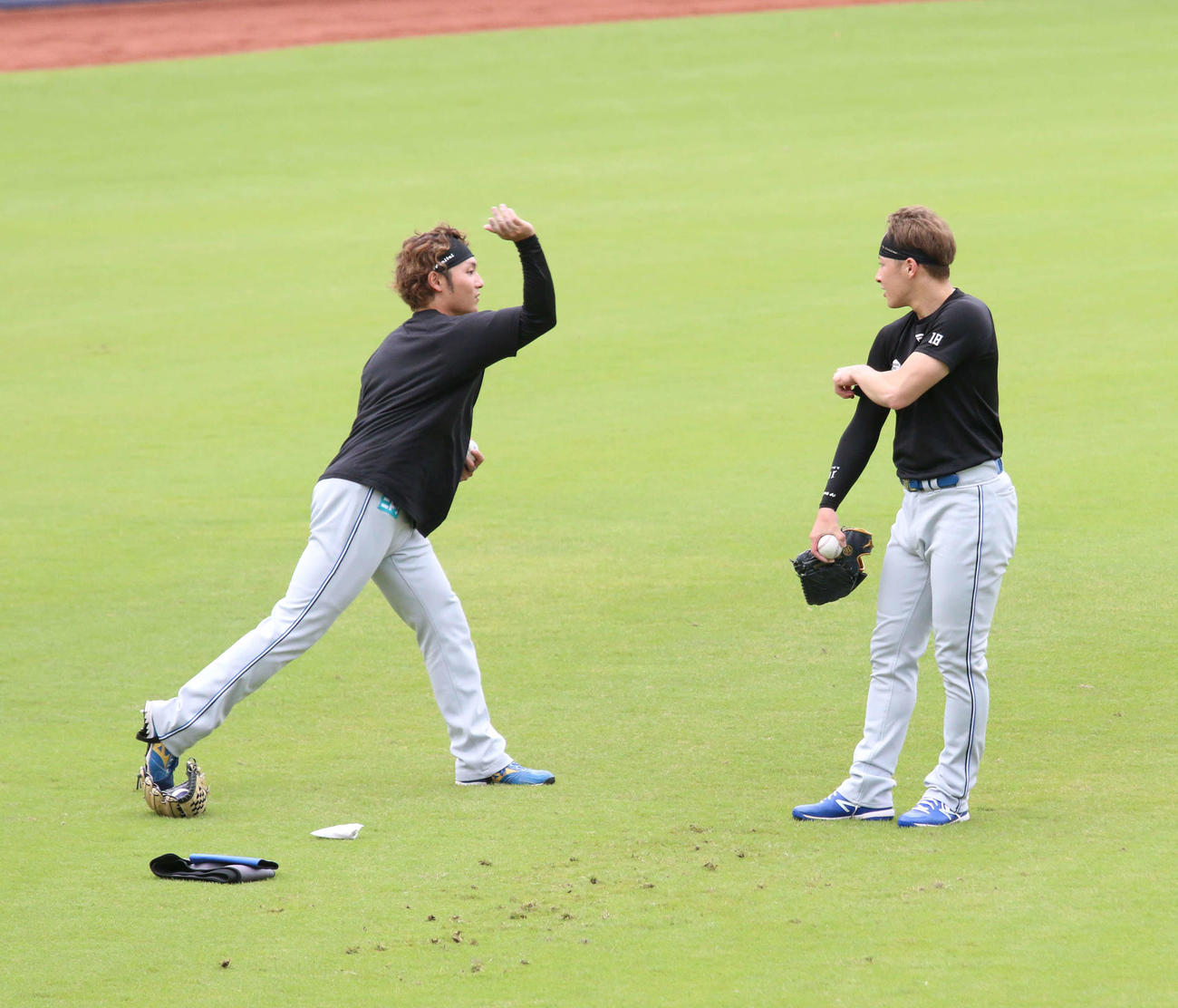 鎌ケ谷で日本ハム伊藤（左）からスライダーを教わる吉田（撮影・木下大輔）