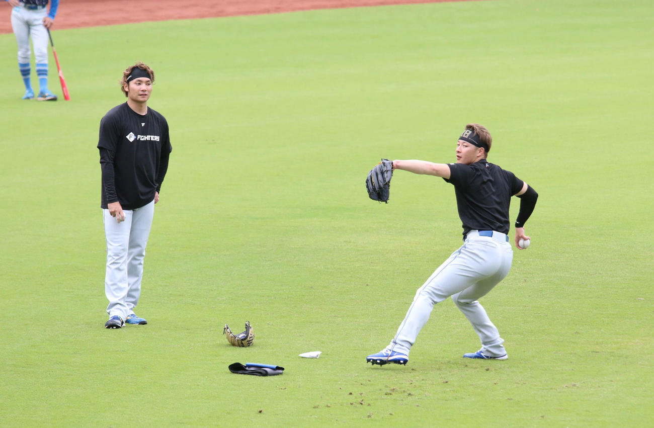 鎌ケ谷で日本ハム伊藤（左）からスライダーを教わる吉田（撮影・木下大輔）