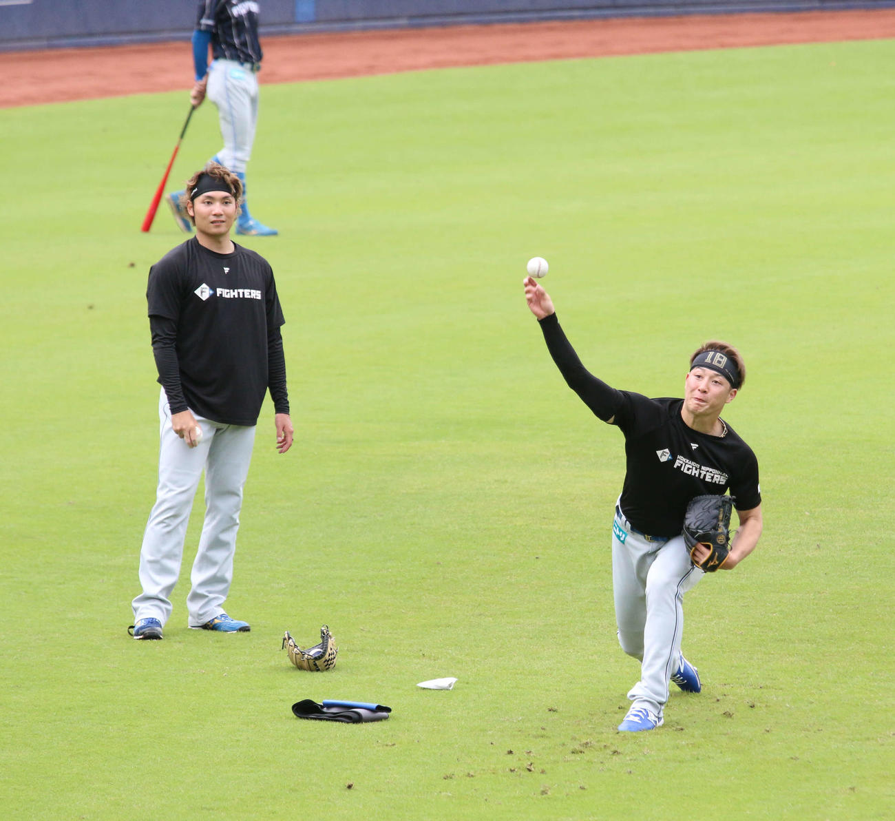 鎌ケ谷で日本ハム伊藤（左）からスライダーを教わる吉田（撮影・木下大輔）