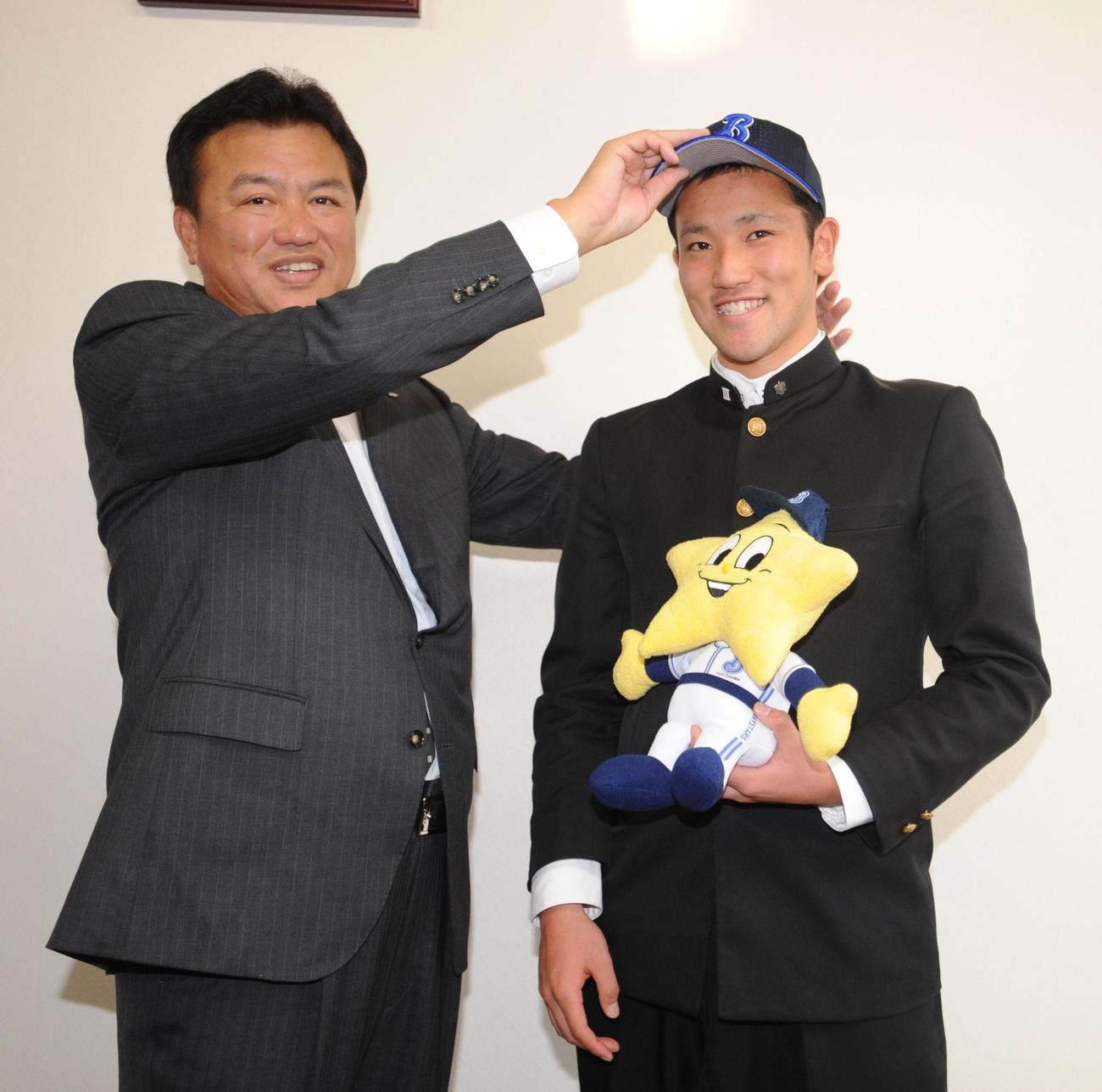 2011年10月　横浜堀井編成部専任部長（左）から帽子をかぶせてもらい笑顔を見せる唐津商・北方悠誠