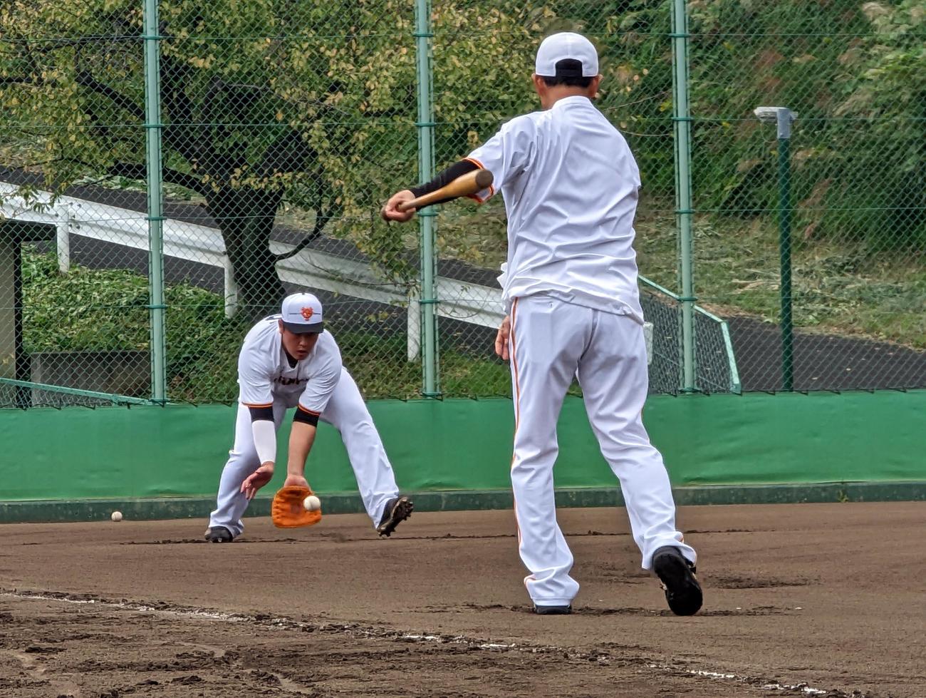 「板グラブ」を着けた岡本和にノックをする巨人の川相次期1軍総合コーチ（撮影・三須一紀）