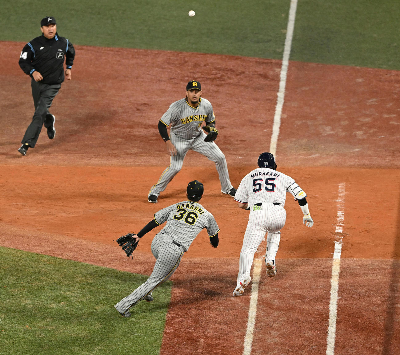 ヤクルト対阪神　7回裏ヤクルト2死満塁、浜地（手前左）は村上（同左）の投手内野安打を一塁へ悪送球し3点失点する（撮影・滝沢徹郎）