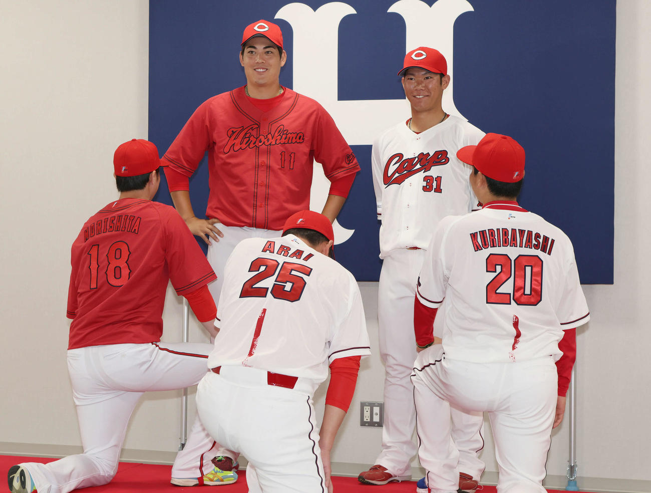 新井貴浩新監督が新ユニホーム発表中にサプライズで登場。左から森下、九里、新井新監督、坂倉、栗林（撮影・加藤孝規）