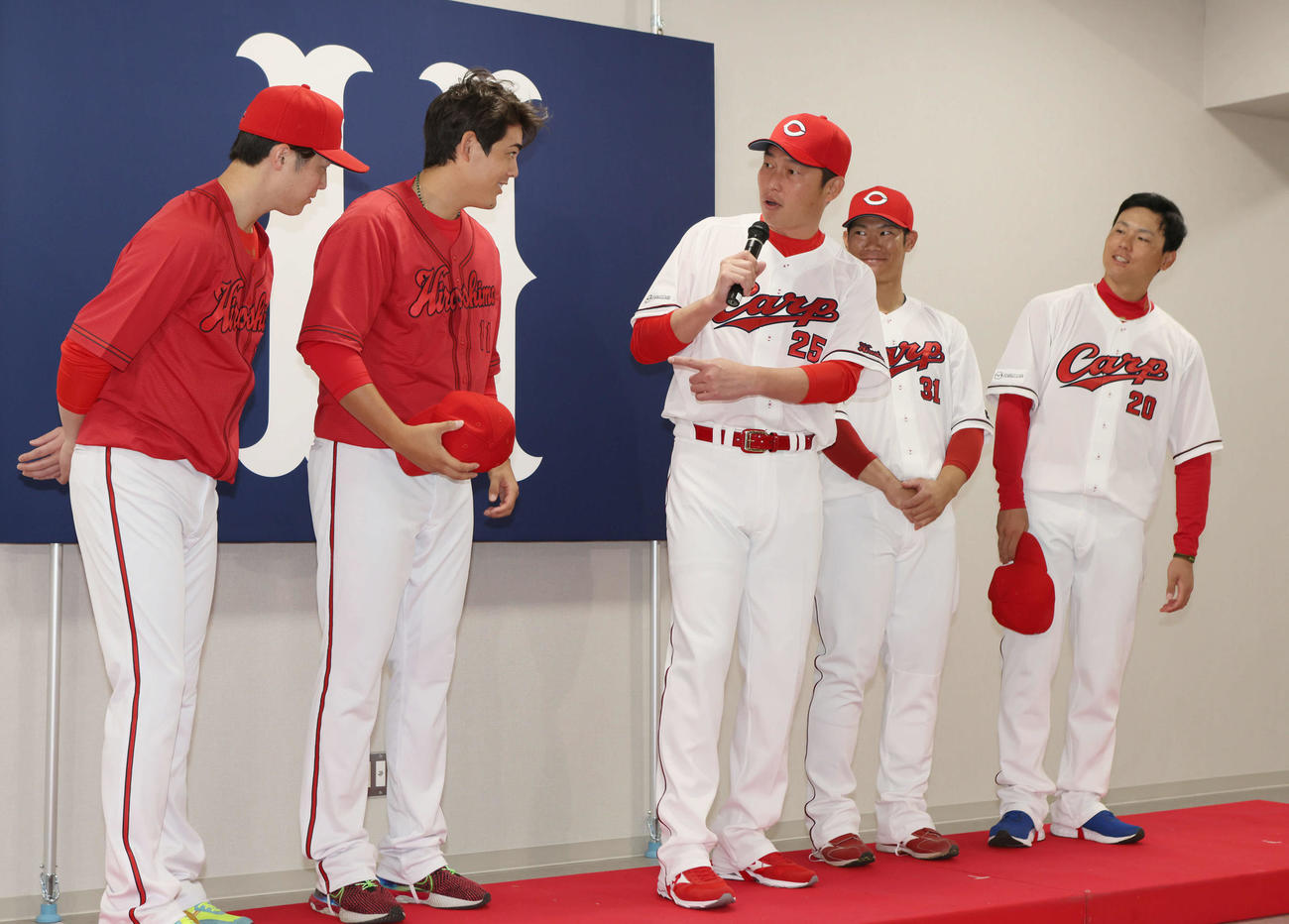新井貴浩新監督が新ユニホーム発表中にサプライズで登場。左から森下、九里、新井新監督、坂倉、栗林（撮影・加藤孝規）