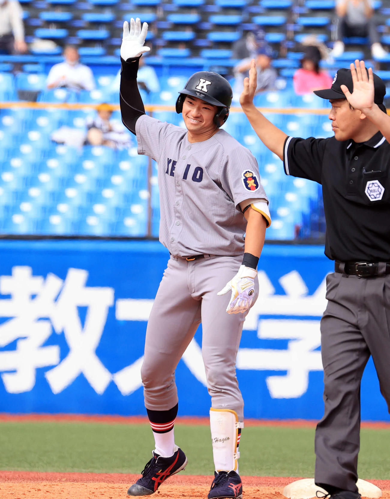 明大対慶大　5回裏慶大2死一、二塁、萩尾は2点適時二塁打を放ち、ベンチに笑顔でポーズ（撮影・浅見桂子）
