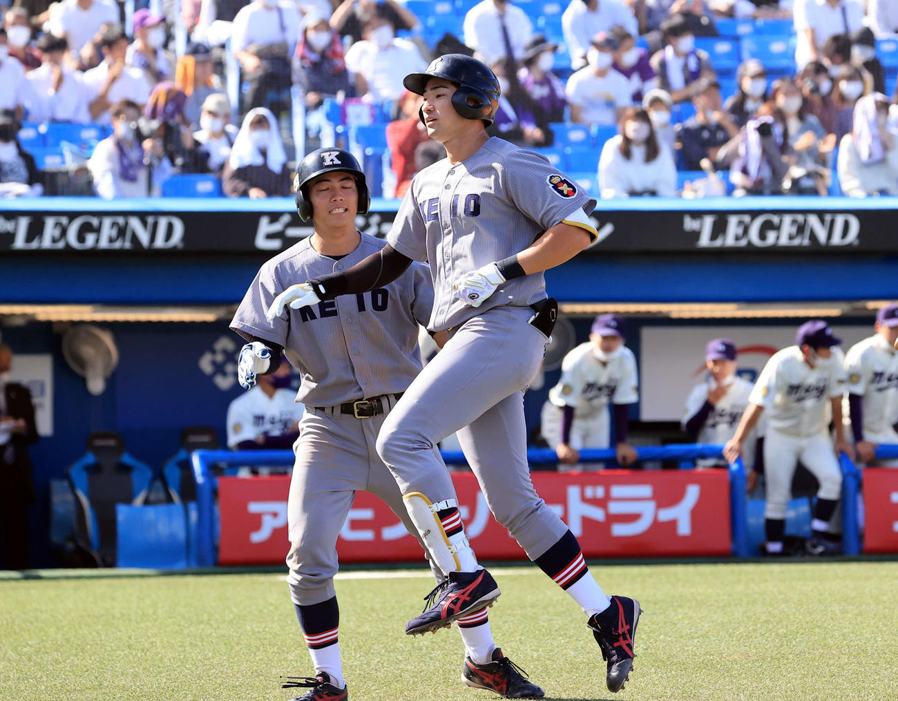 明大対慶大　6回裏慶大2死一、二塁、萩尾は3点本塁打を放ち、生還するとジャンプしてベンチに戻る（撮影・浅見桂子）