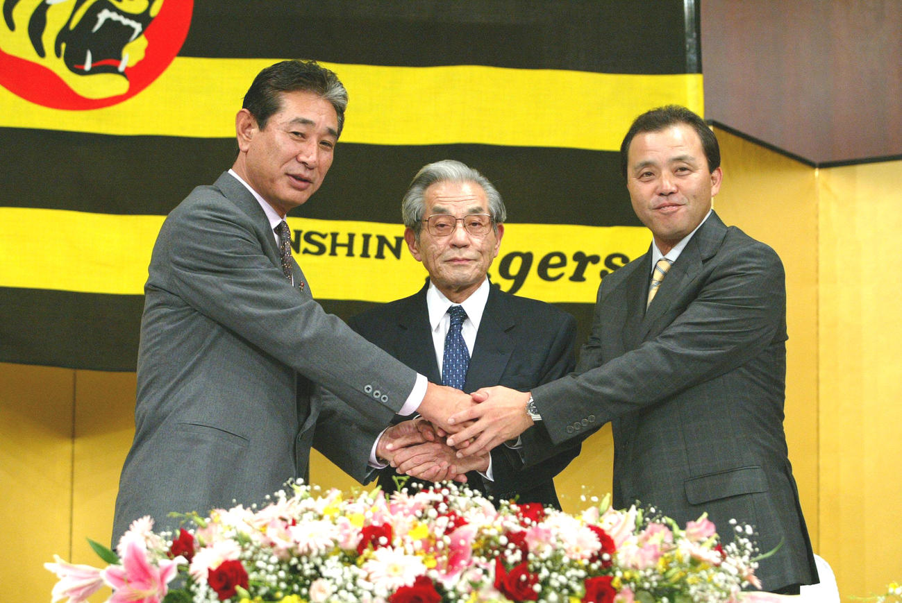 03年、阪神岡田新監督（右）は久万オーナー（中央）、勇退した星野監督（左）と握手を交わす