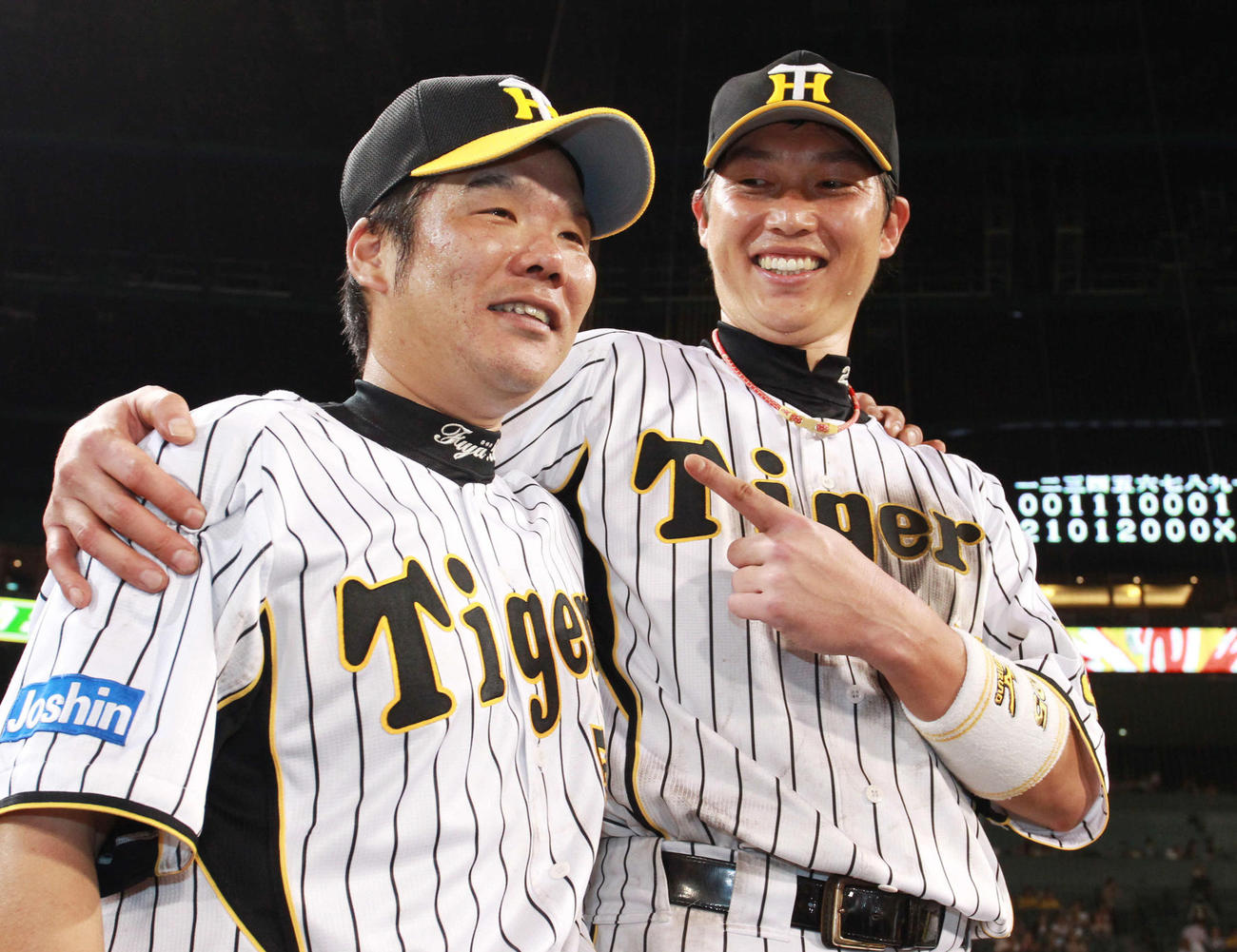 11年、本塁打を放ち勝利に貢献した藤井彰（左）と新井が肩を抱き合う