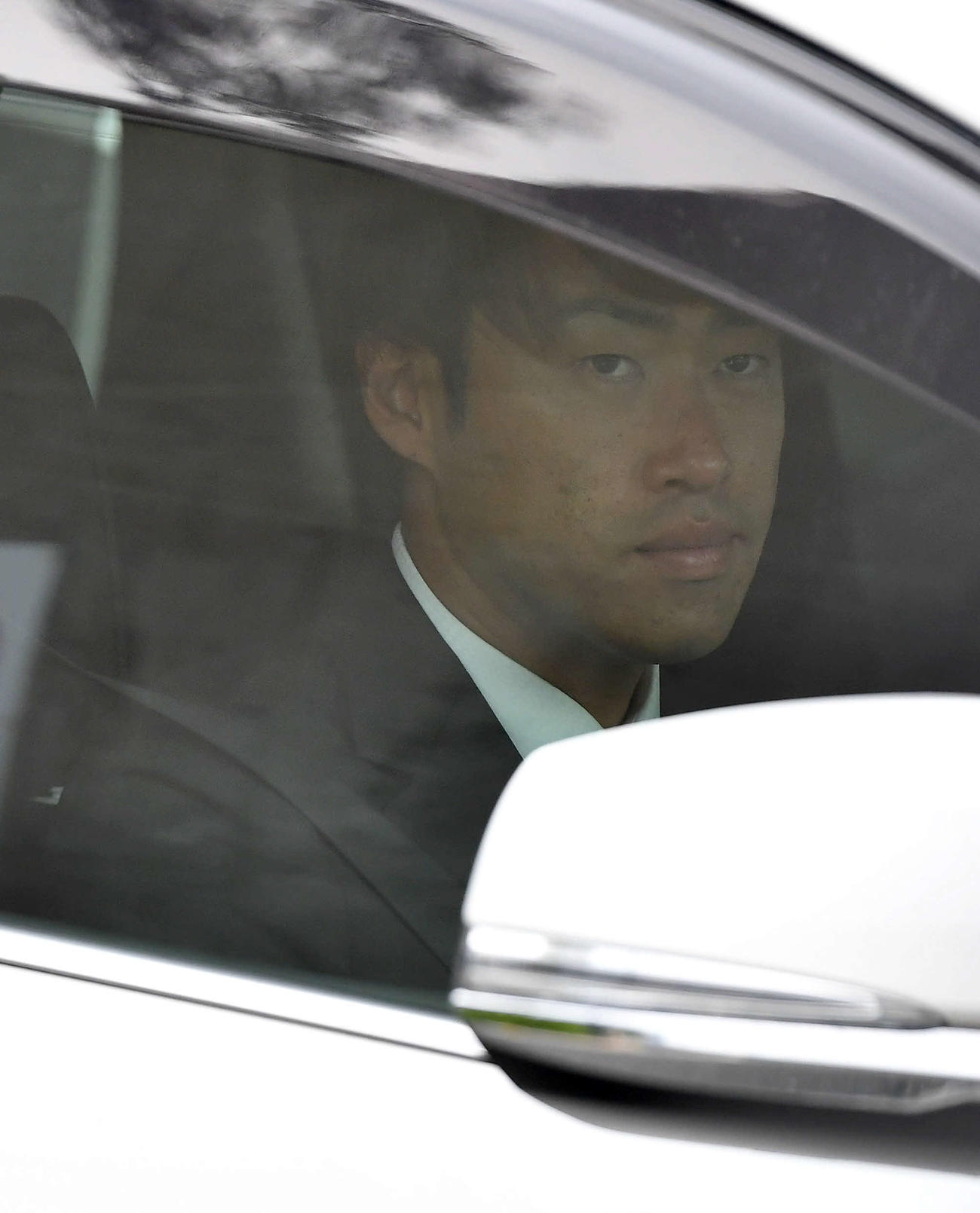球団事務所での話し合いを終え、車で引き揚げる秋吉（撮影・岩下翔太）