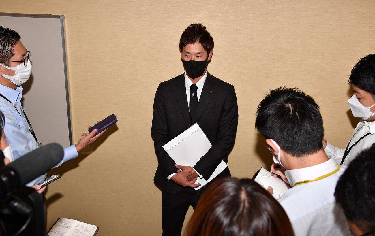 球団事務所での話し合いを終え、囲み取材を受ける高田（撮影・岩下翔太）