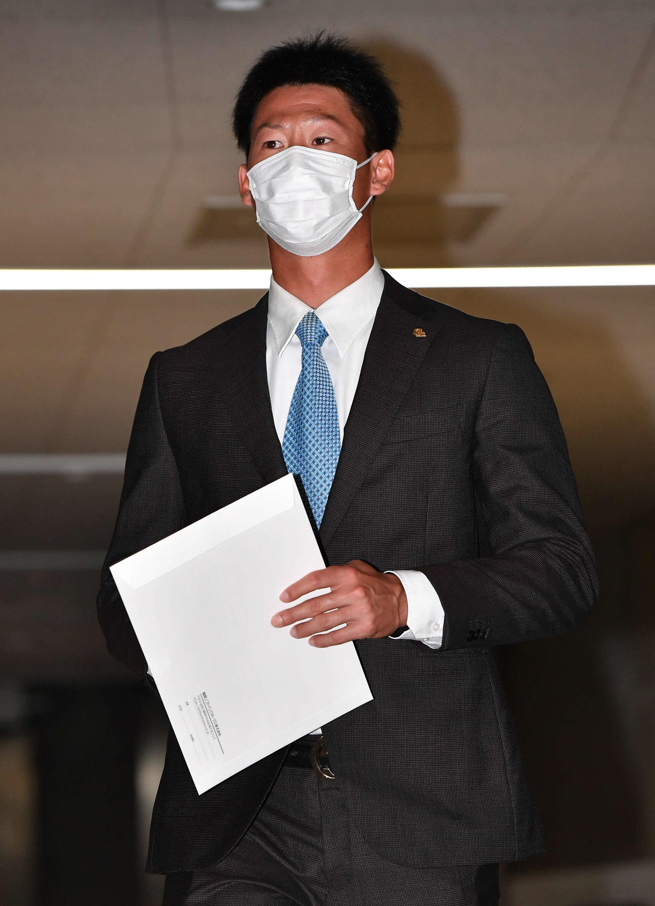 球団事務所での話し合いを終え、囲み取材へ向かう真砂（撮影・岩下翔太）