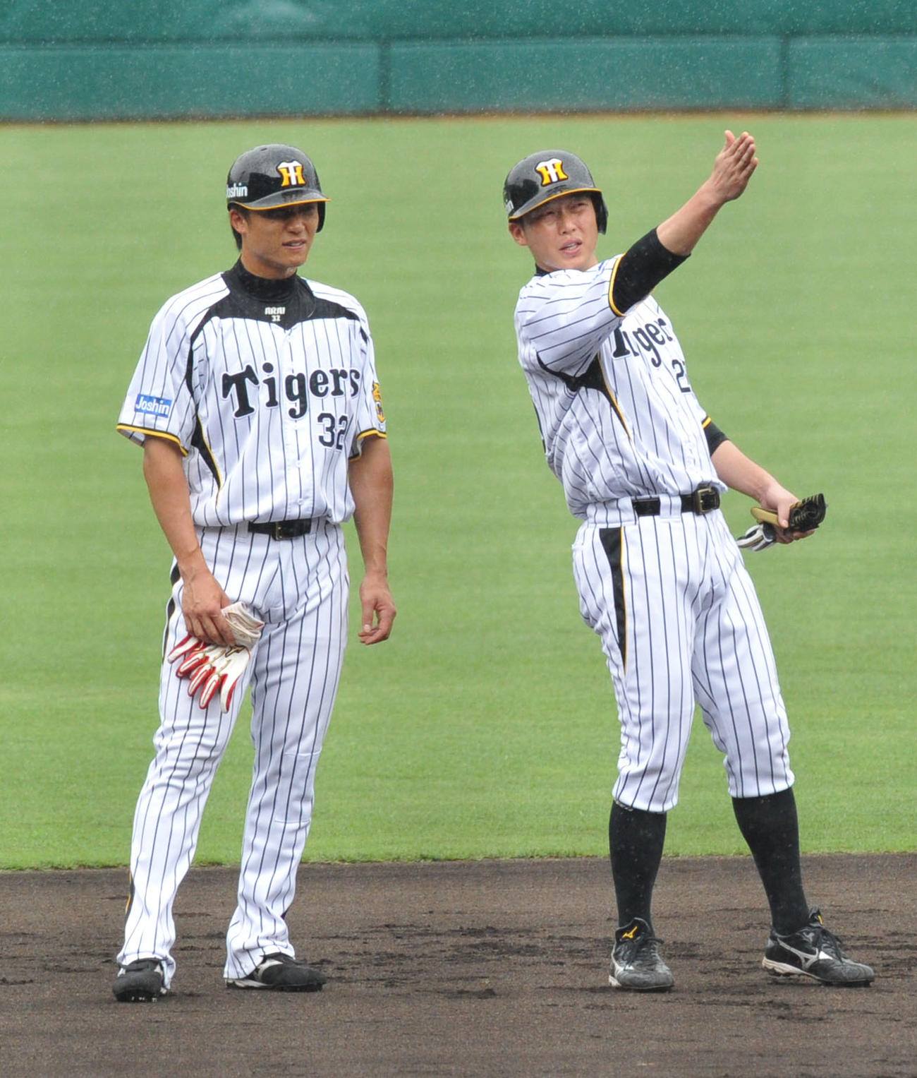 2013年6月19日、阪神練習中に弟の新井良太（左）の打撃指導をする兄の貴浩