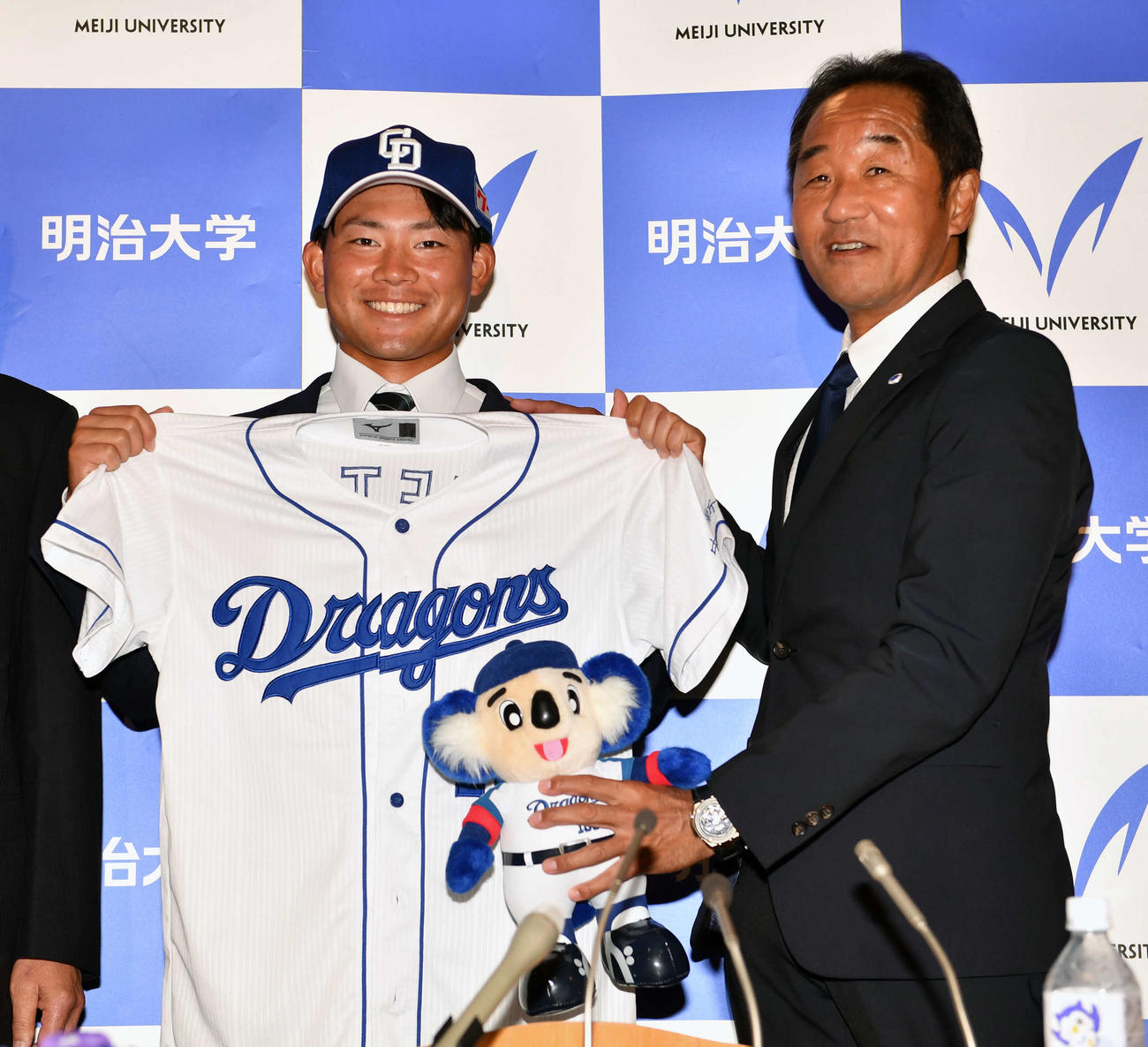 中日から2位に指名された明大・村松（左）は田中監督から祝福される（撮影・柴田隆二）