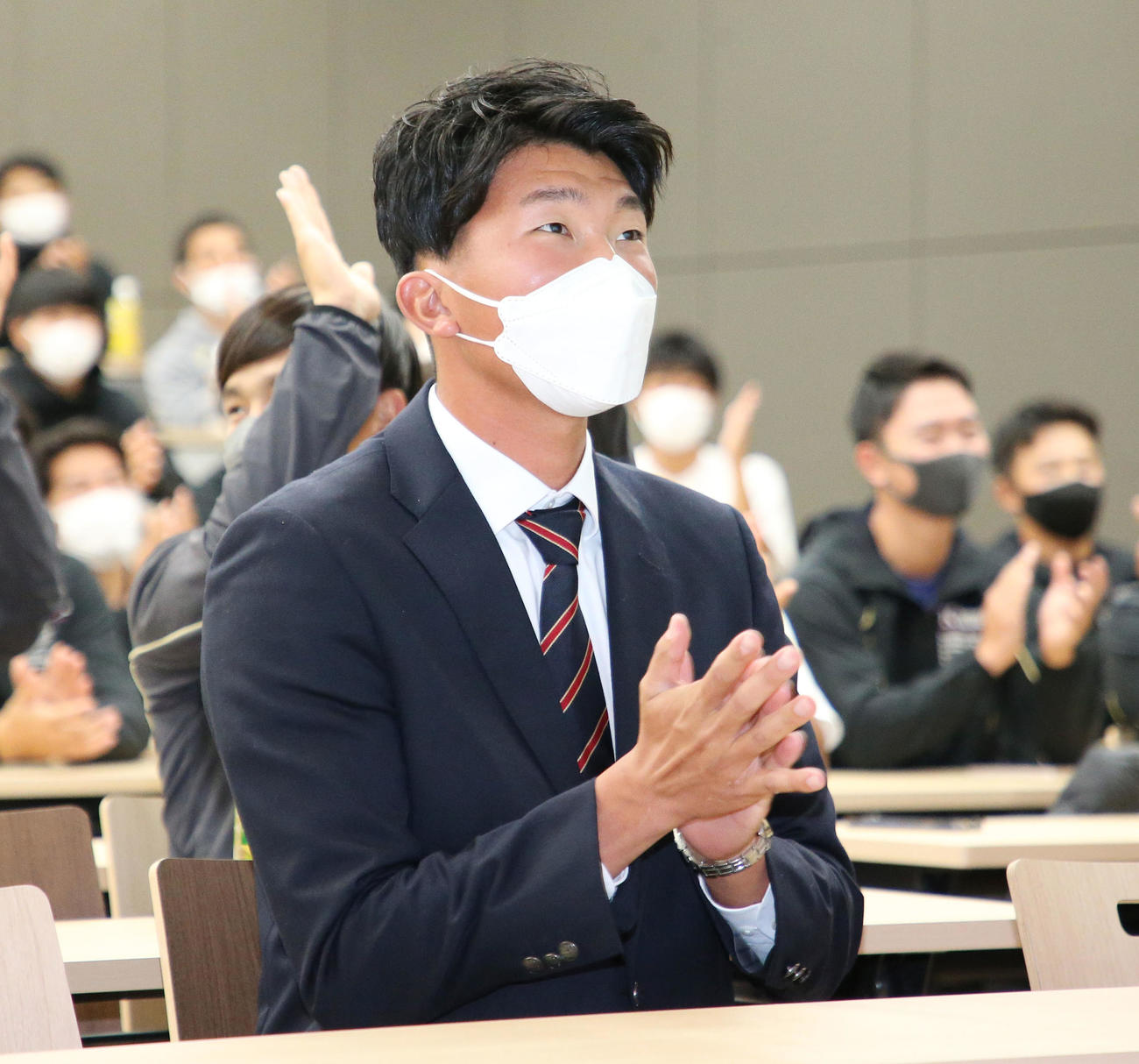 国学院大出身の吉村貢司郎投手がヤクルトに指名され拍手する田中千晴投手（撮影・宮地輝）