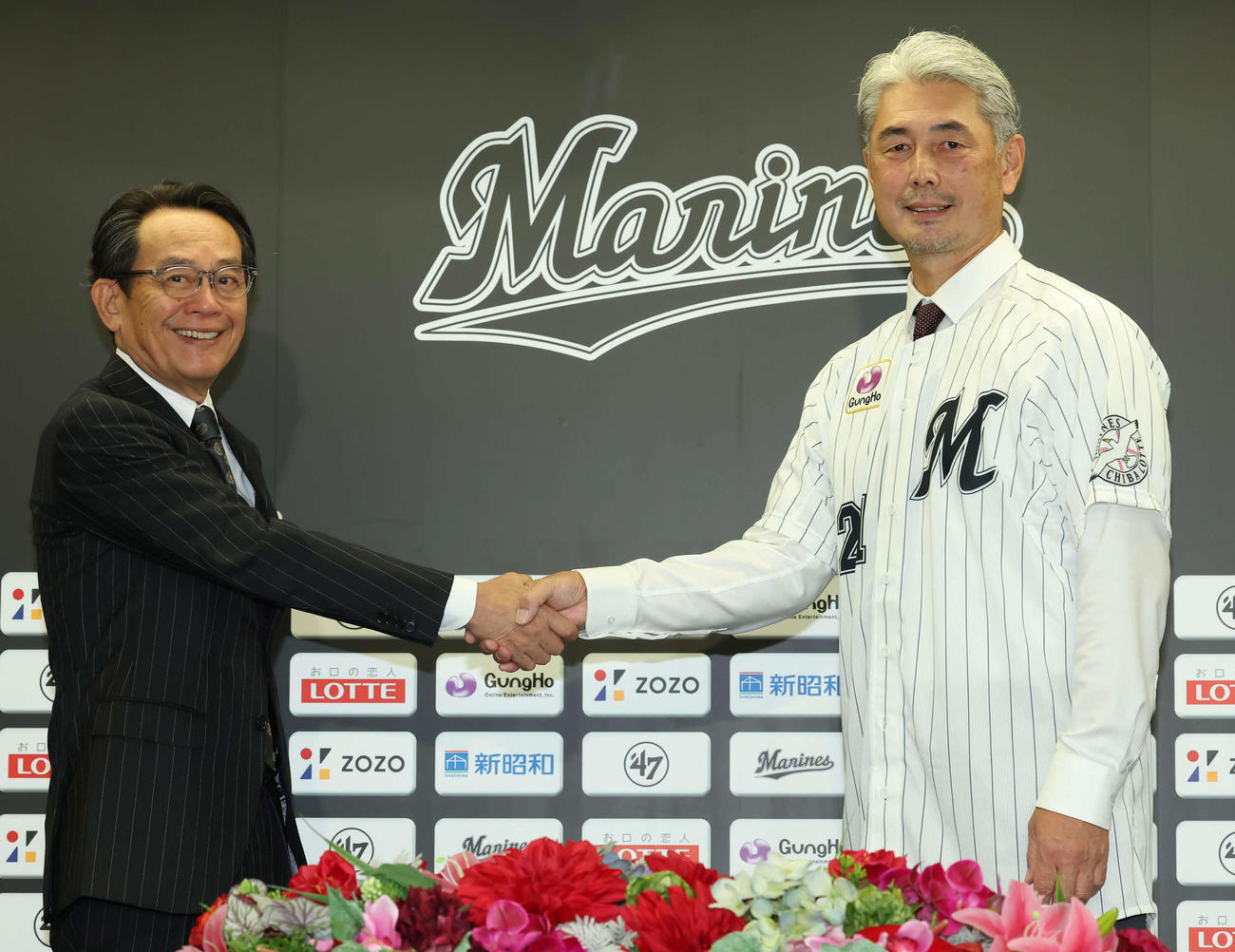河合球団社長兼オーナー代行（左）と握手するロッテ吉井新監督（撮影・丹羽敏通）