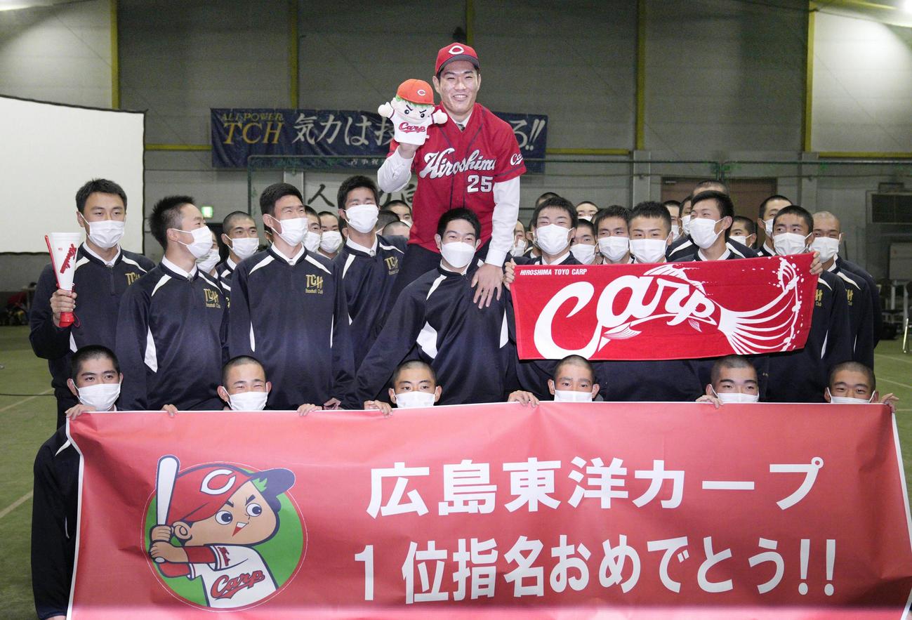広島から1位指名を受け、チームメートと共に笑顔を見せる苫小牧中央高の斉藤優汰投手（中央上）（共同）