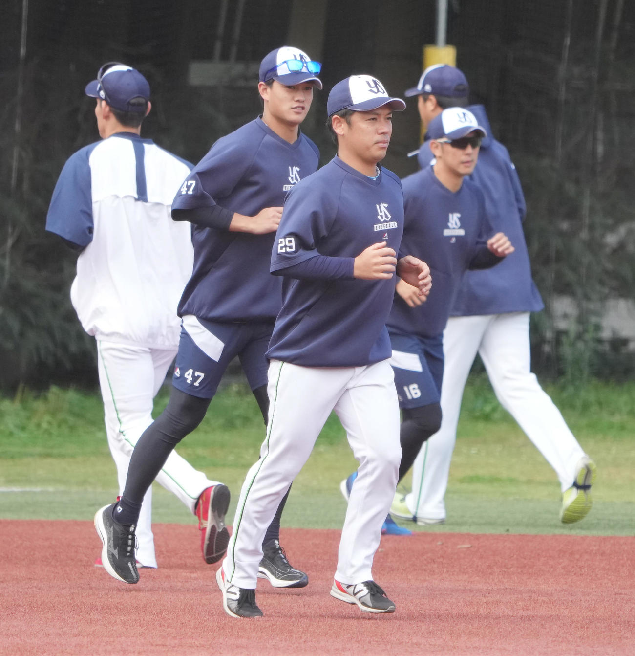 投手陣練習でウオーミングアップするヤクルト小川（中央）（撮影・小沢裕）