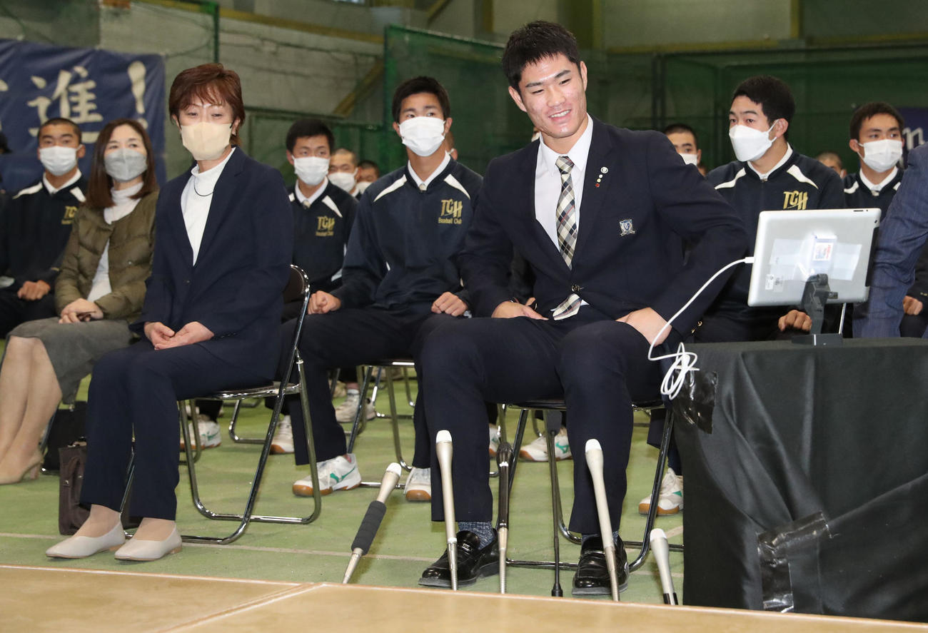 広島からドラフト1位指名を受け笑顔を見せる苫小牧中央・斉藤（中央）。左は母明美さん（撮影・佐藤翔太）