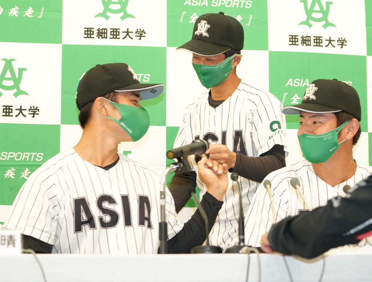 中日にドラフト6位で指名された亜大・田中（中央）はソフトバンク5位指名の松本（左）とグータッチ。右は西武4位指名の青山（撮影・鈴木みどり）