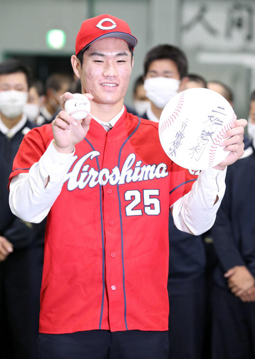 広島からドラフト1位指名を受けた苫小牧中央の斉藤は「二桁勝利」としたため記念撮影に応じる(撮影・佐藤翔太)