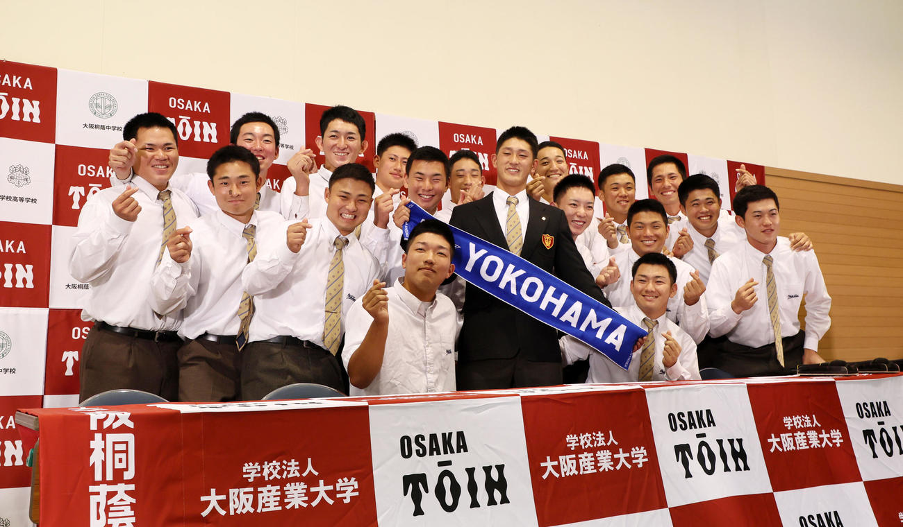 DeNAから1位指名を受け3年生のチームメートと記念写真に収まる阪桐蔭の松尾（撮影・加藤哉）