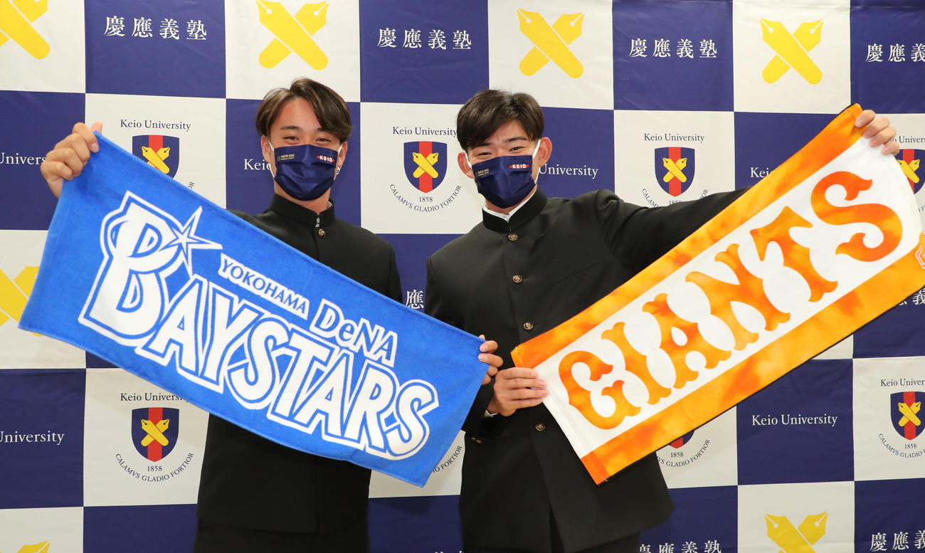 ドラフト指名を受け応援タオルを手に笑顔の慶大・萩尾匡也（右）と橋本達弥（代表撮影）