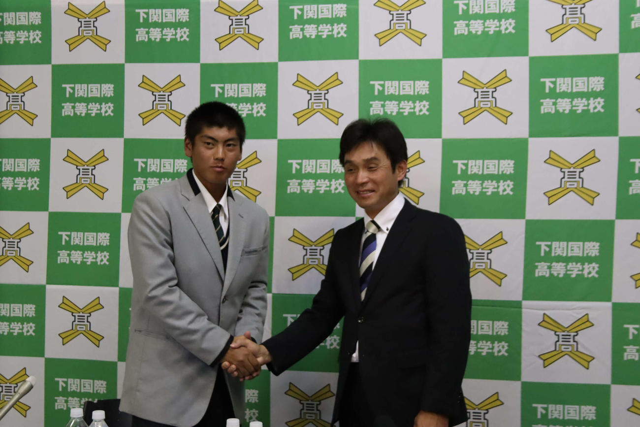 楽天からドラフト指名され握手する下関国際の古賀康誠（左）と坂原秀尚監督