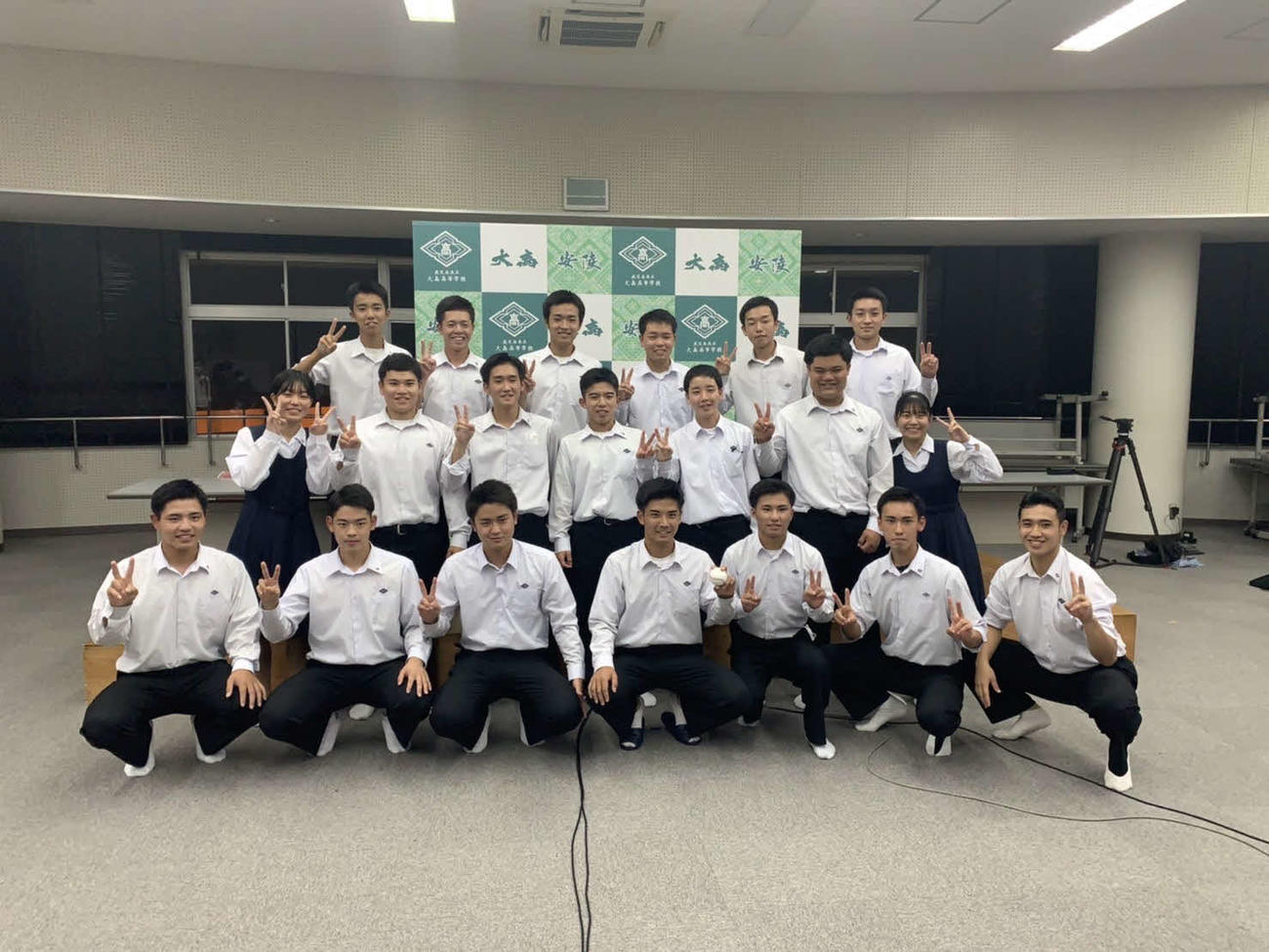 大島ナインとポーズをとる大島・大野稼頭央（最前列右から4番目。学校提供）