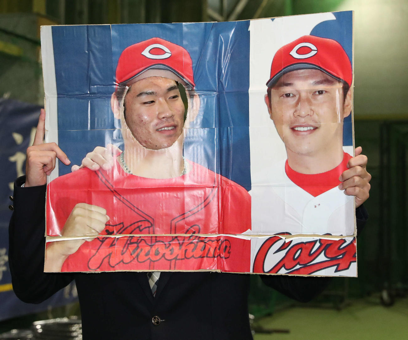 広島からドラフト1位指名を受けた苫小牧中央の斉藤は手作りの新井新監督ボードを手に見つめる（撮影・佐藤翔太）