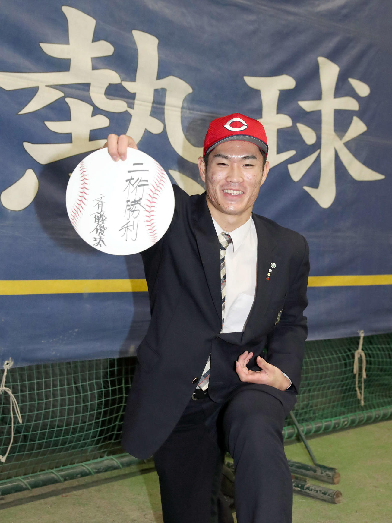 広島からドラフト1位指名を受けた苫小牧中央の斉藤は「二桁勝利」としたため笑顔で投げる素振りをする（撮影・佐藤翔太）