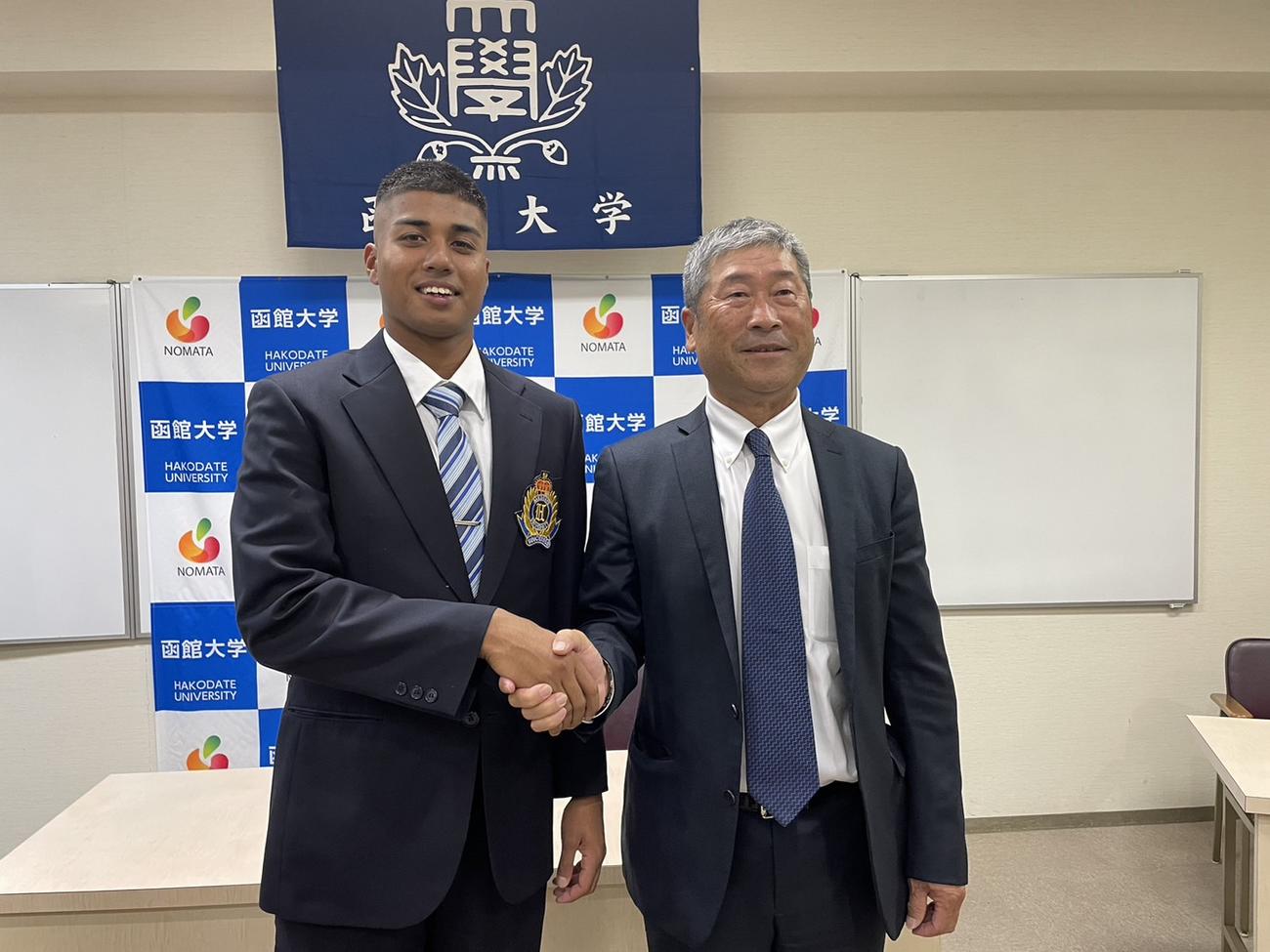 楽天育成3位指名された函館大の竹下投手と阪内監督は握手（提供・函館大学野球部）