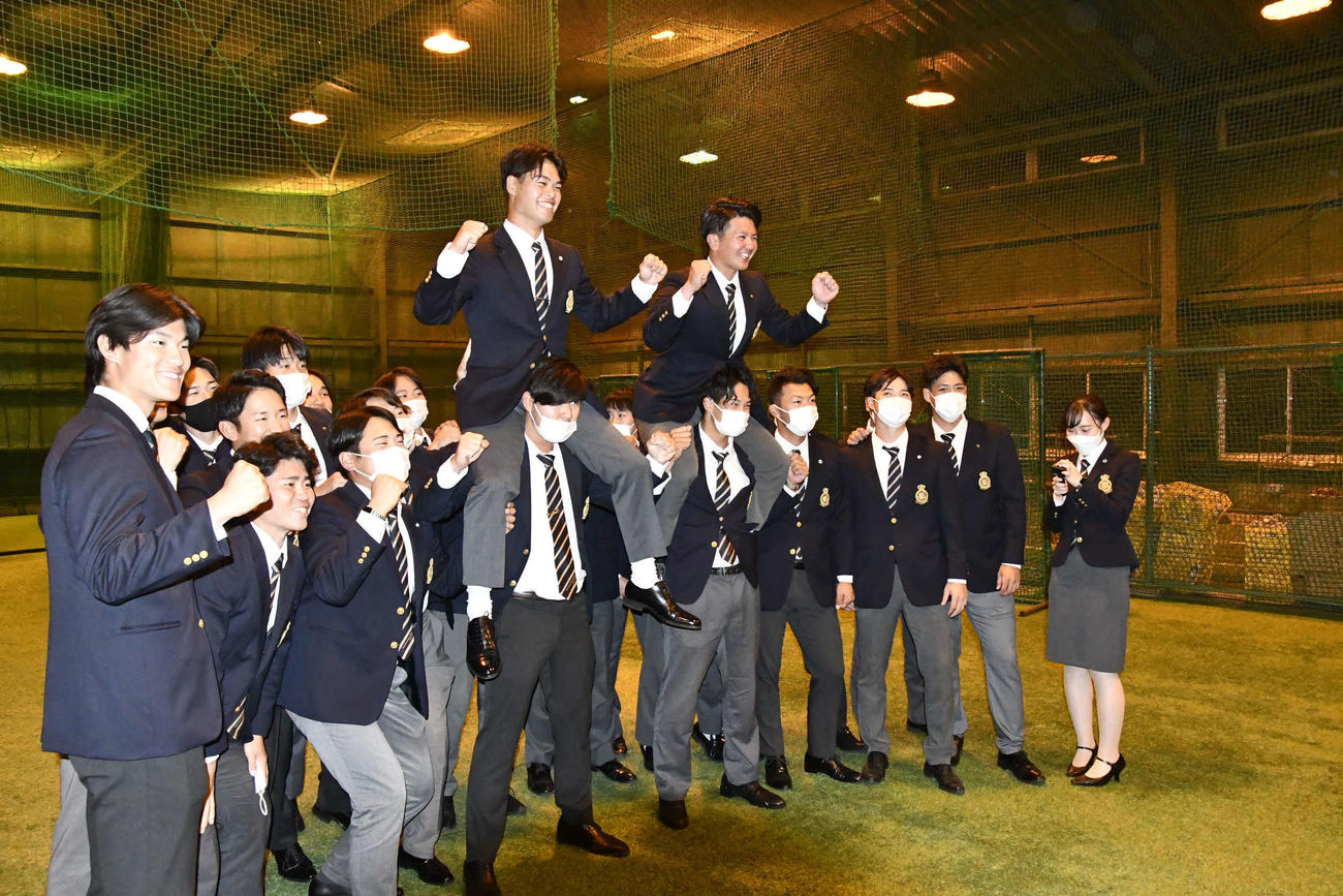 仲間たちの歓喜の輪に加わり、肩車される左から是沢涼輔捕手と村上喬一朗捕手（撮影・平山連）