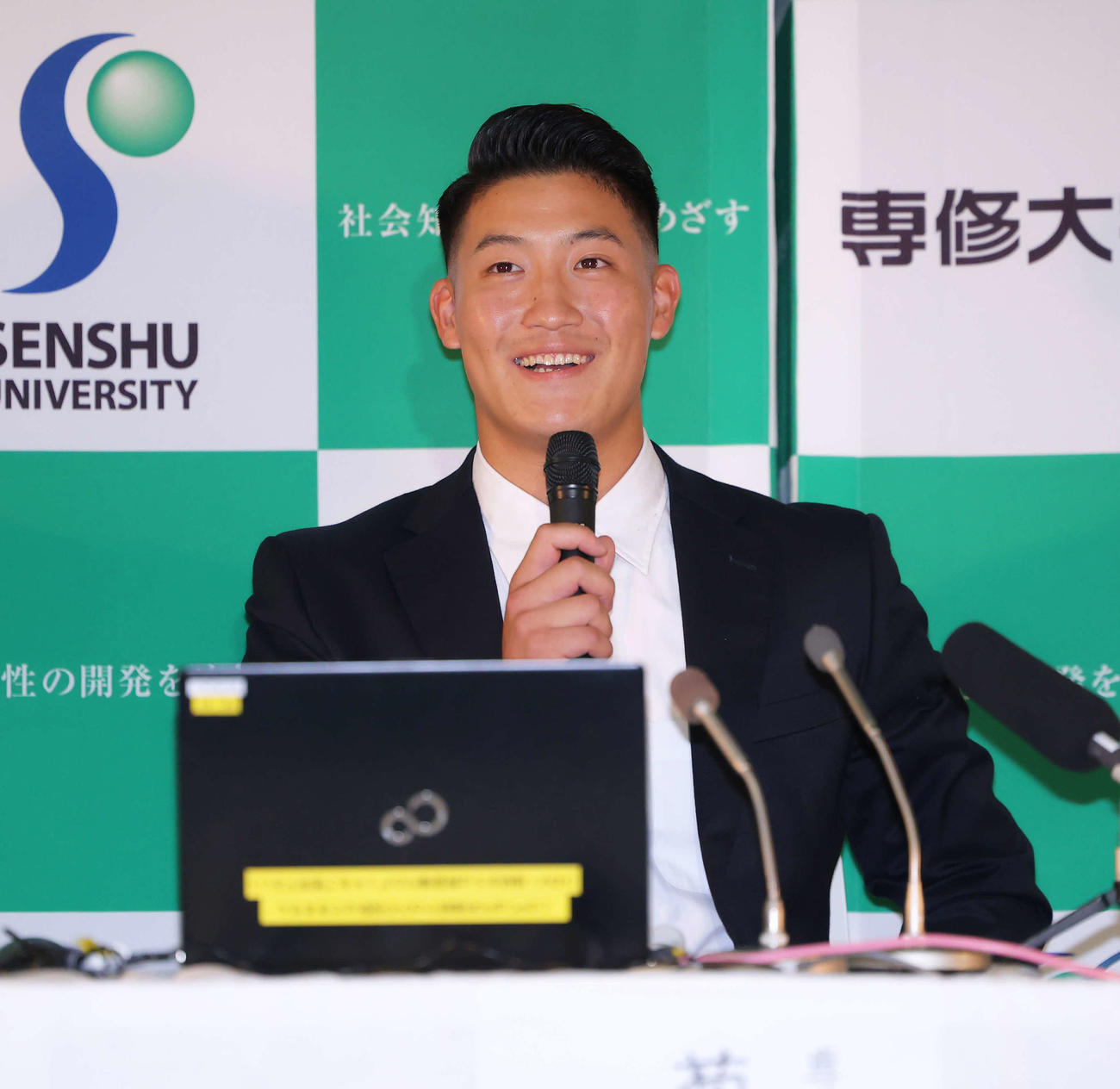 ロッテ外れ1位指名を受け、笑顔で会見に臨む専大・菊地（撮影・河田真司）