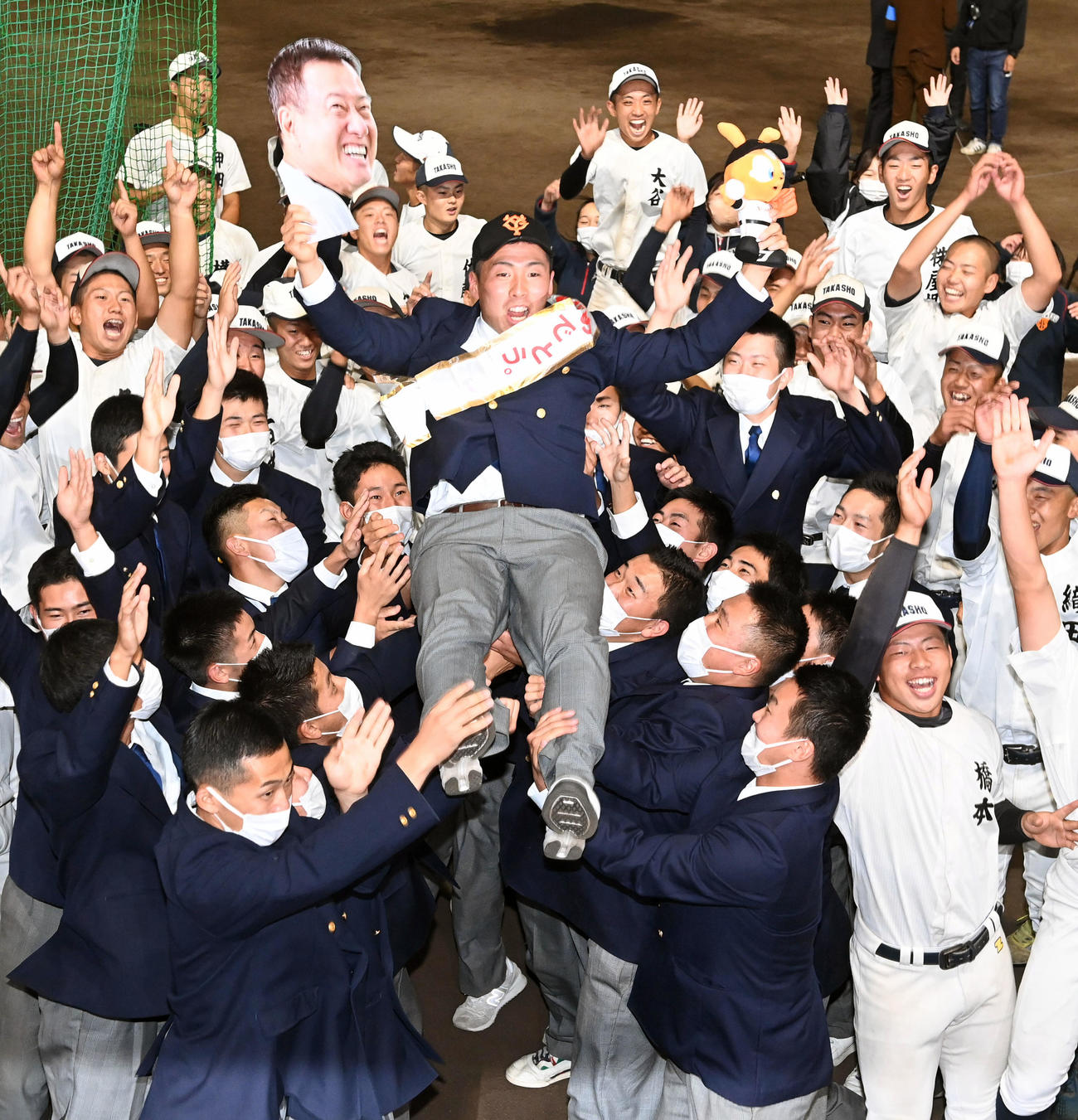 巨人から指名された高松商・浅野は原監督の写真とジャビット人形を手にナインから胴上げされる（撮影・前岡正明）