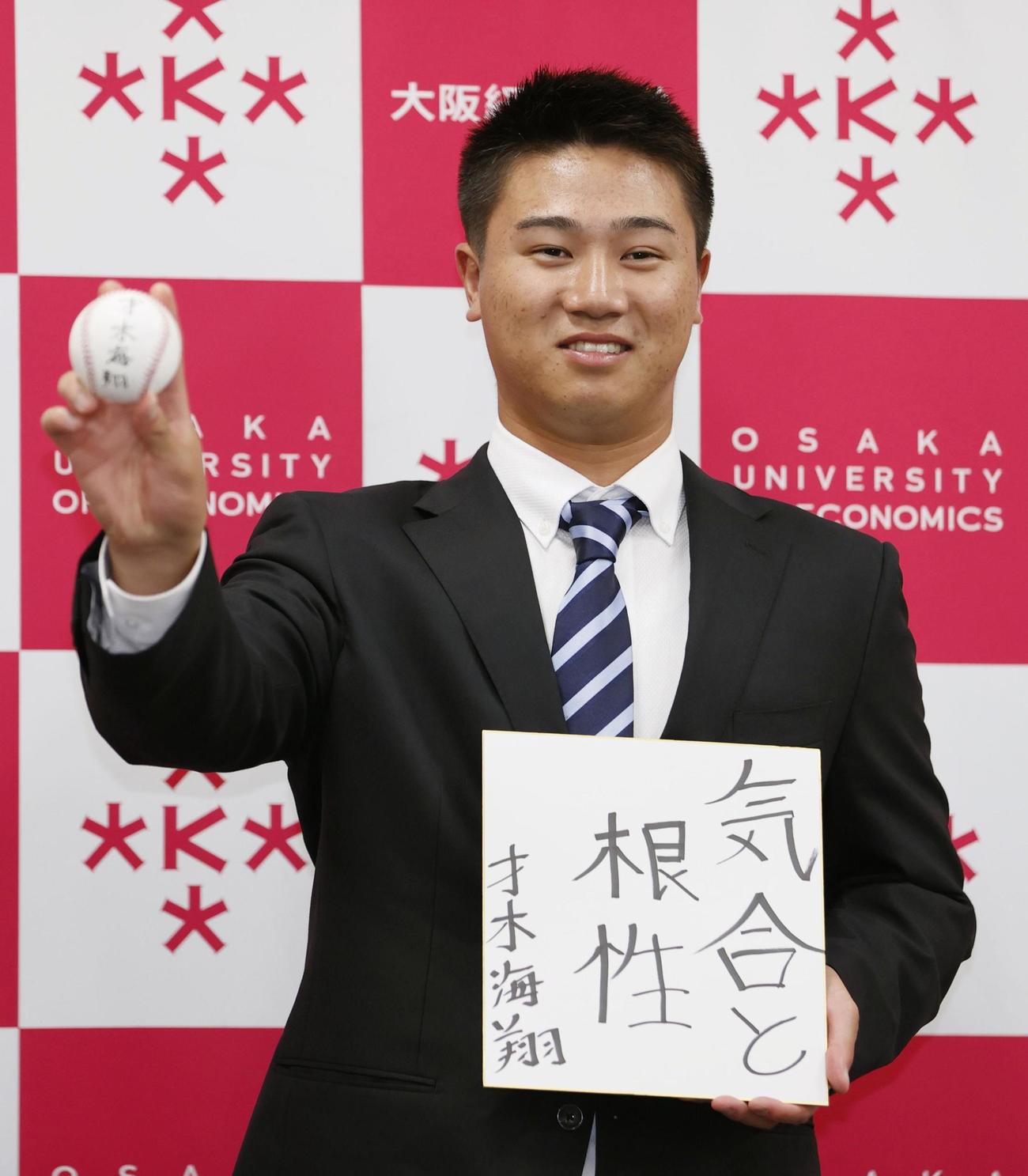 オリックスから育成2位指名を受け、笑顔でポーズをとる大経大・才木