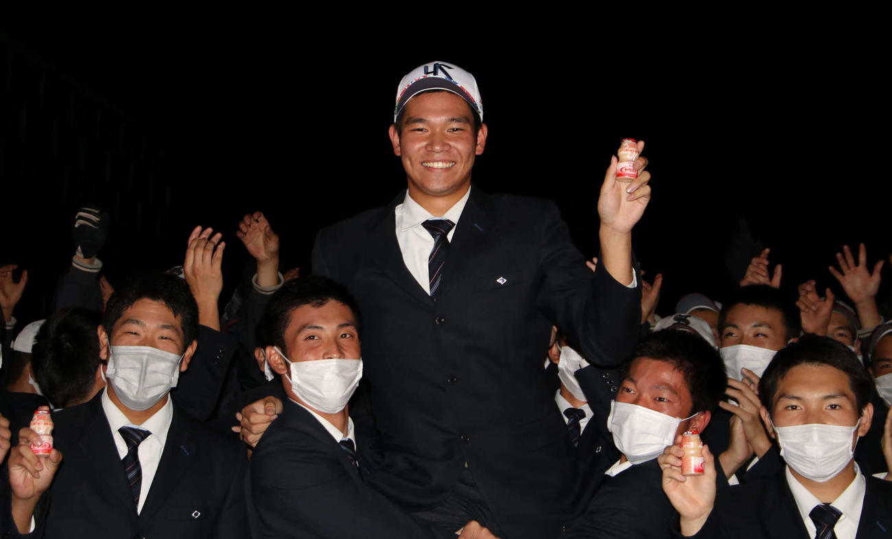 ヤクルトから4位指名を受け、ヤクルトを手に笑顔をみせる知内・坂本（撮影・山崎純一）
