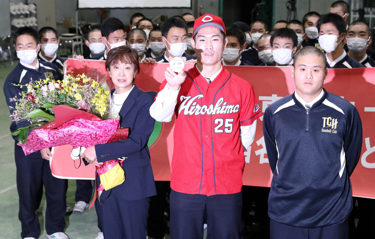 広島からドラフト1位指名を受けた苫小牧中央の斉藤（中央）は母明美さん（左）と弟翔太くんと記念撮影に応じる（撮影・佐藤翔太）