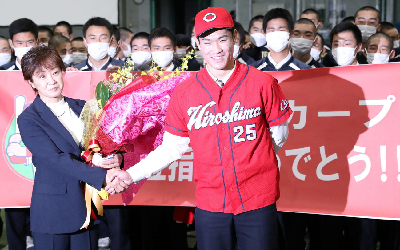 広島からドラフト1位指名を受け母明美さん（左）と笑顔で握手をする苫小牧中央・斉藤（撮影・佐藤翔太）