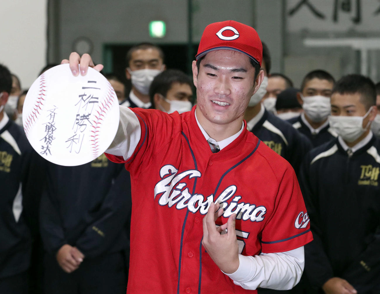 広島からドラフト1位指名を受けた苫小牧中央の斉藤は「二桁勝利」としたため記念撮影に応じる（撮影・佐藤翔太）