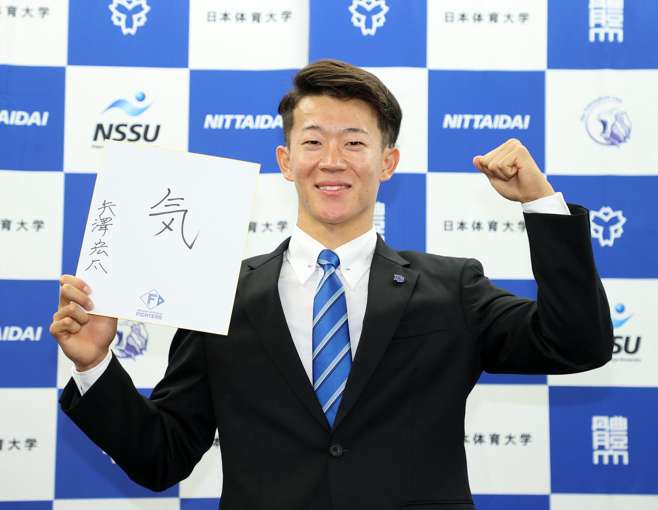 色紙に「気」と書きガッツポーズする日体大・矢沢（撮影・鈴木正人）