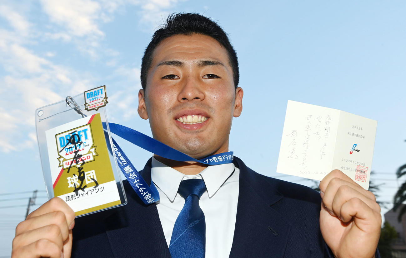 巨人原監督の直筆メッセージが入った当たりくじとドラフト会議入場証を手に笑顔の高松商・浅野（撮影・前岡正明）