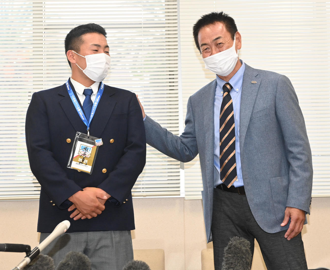 指名あいさつで水野スカウト部長（右）の激励を受ける高松商・浅野（撮影・前岡正明）