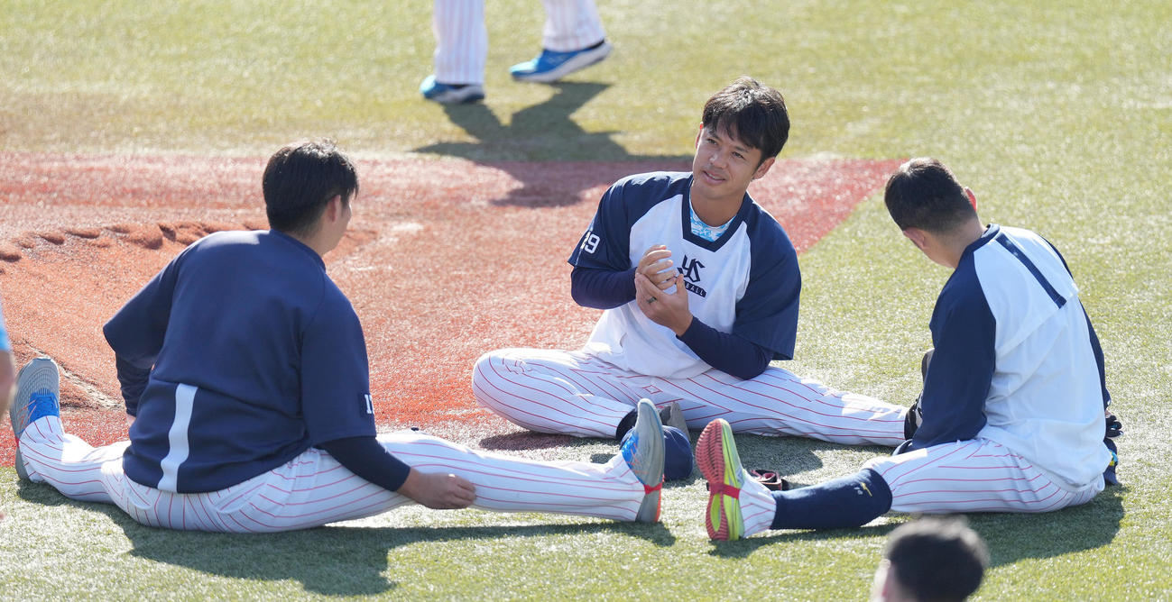 ストレッチしながら談笑するヤクルト小川（中央）（撮影・鈴木みどり）