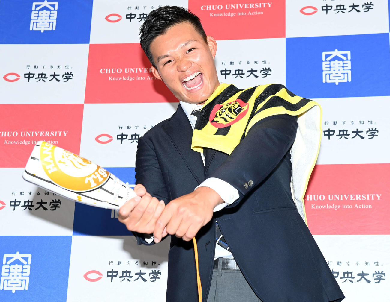 阪神グッズを手にポーズを決める中大・森下（撮影・たえ見朱実）